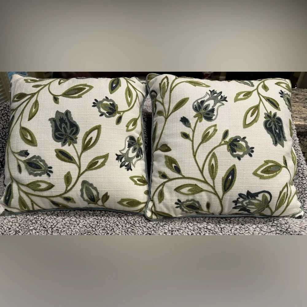Two decorative pillows with green/blue tulip design.